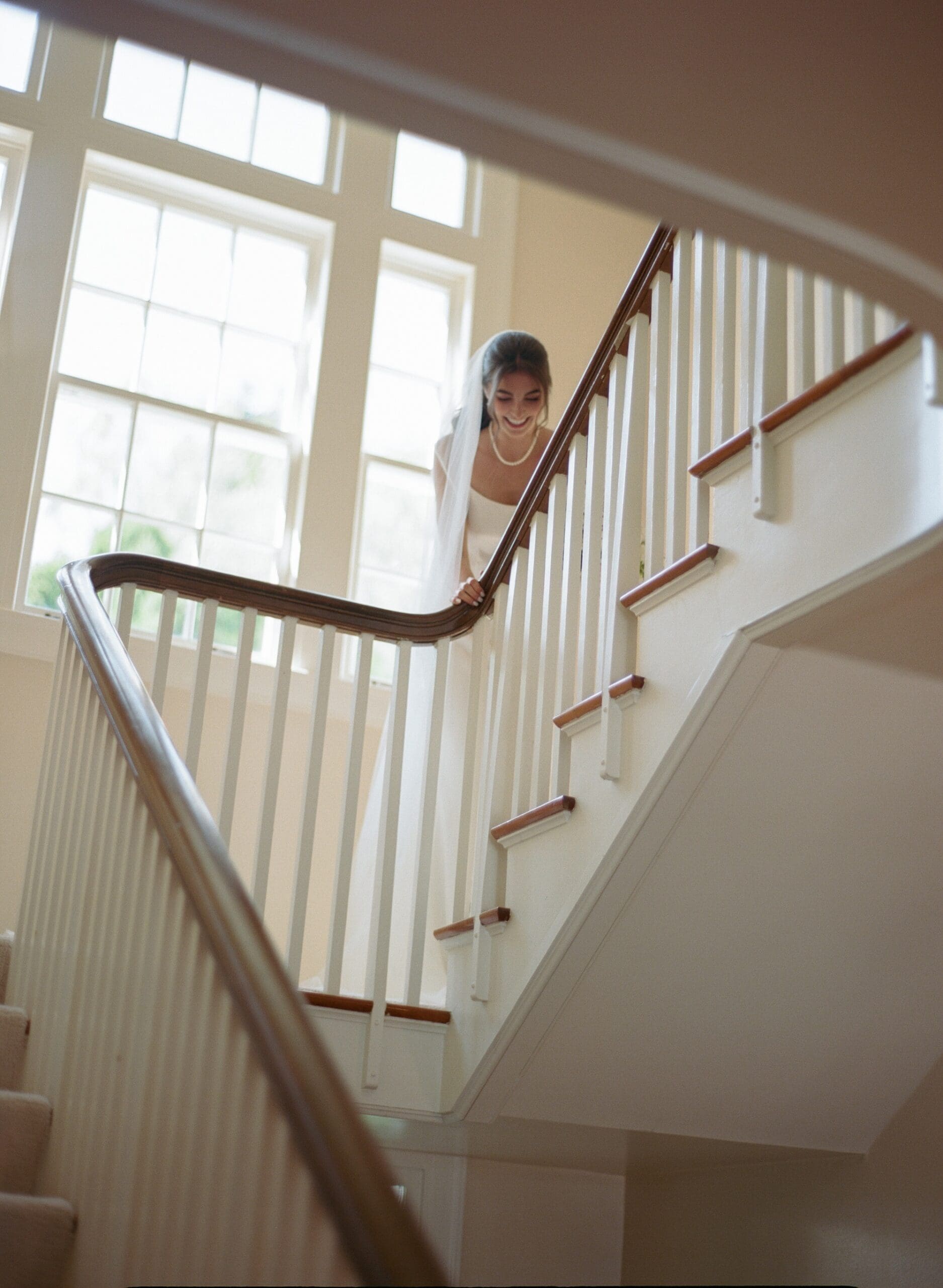 Bride looks down from the stairs at The Admiral's House